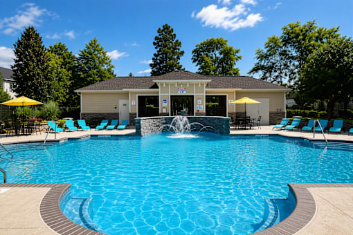 A pool with a fountain in the middle of it.