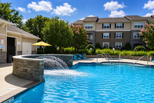 A swimming pool with a waterfall feature in the middle of it.