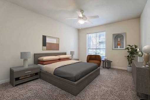 A bedroom with a bed, nightstand, and a plant.