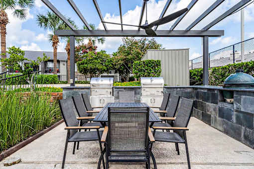 A patio with a table and chairs under a roof.