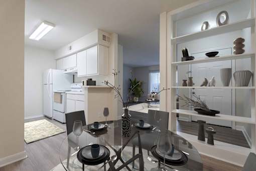 A modern kitchen with a glass dining table and chairs.