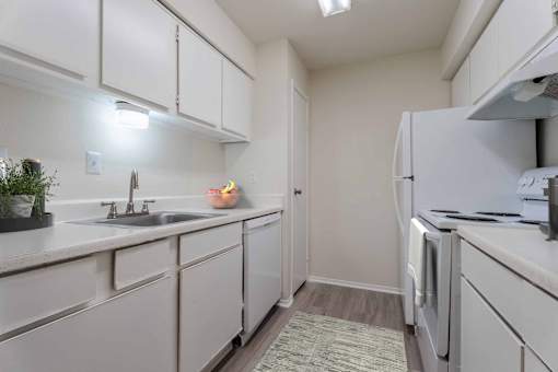A kitchen with white cabinets and a sink.