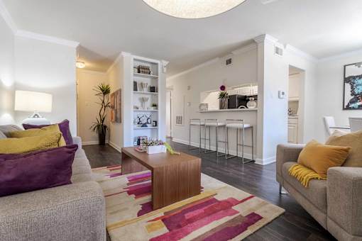 A living room with a grey couch and a wooden coffee table.at 2400 Briarwest Apartments, Houston, Texas