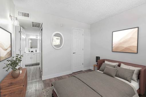 A bedroom with a large bed and a painting on the wall.