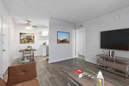 A living room with a brown chair and a painting on the wall.
