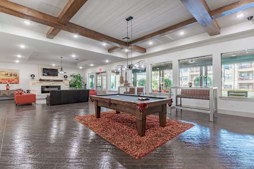 Community Clubroom with Large Windows and a Pool Table and Benches  at Legacy Brooks, San Antonio