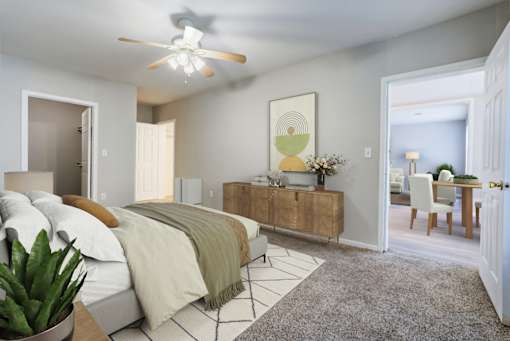 A bedroom with a bed, a dresser, and a ceiling fan.