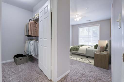 A bedroom with a bed, nightstand, and a closet with clothes.