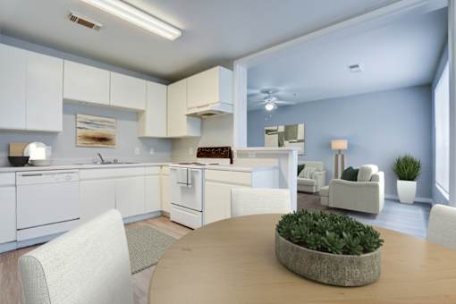 A modern kitchen with white cabinets and a dining table with a plant on it.