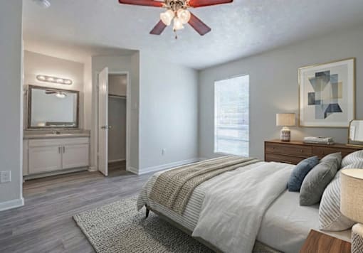 A bedroom with a large bed and a ceiling fan.