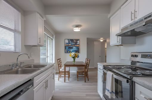 A kitchen with a table and chairs in the middle.