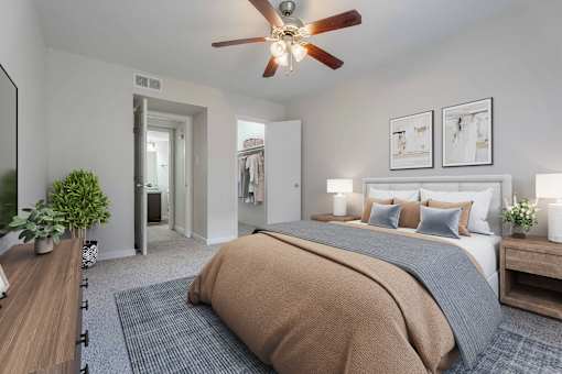 A bedroom with a large bed and a ceiling fan.