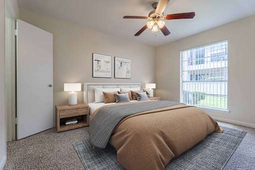 A bedroom with a large bed and a ceiling fan.
