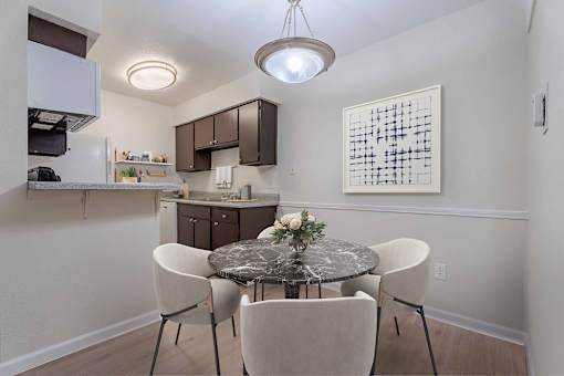 A kitchen with a table and chairs in the foreground.