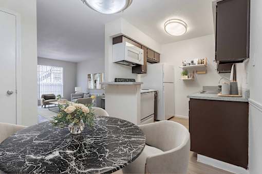 A kitchen with a marble table and a fridge.