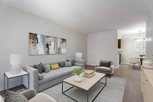 A living room with a grey couch, a coffee table, and a lamp.