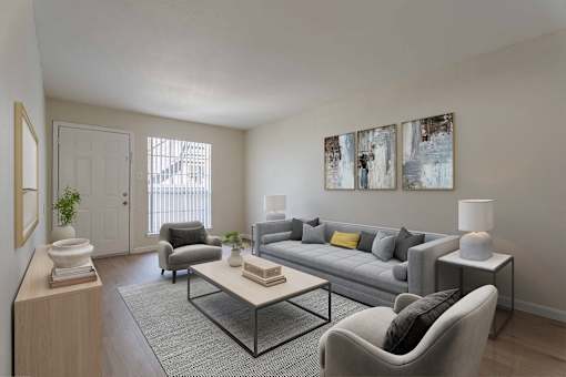 A living room with a grey couch, a grey armchair, a coffee table, a lamp, and two paintings on the wall.