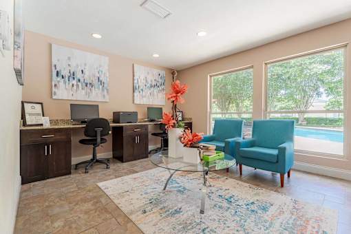 A room with a blue chair and a table with flowers on it.