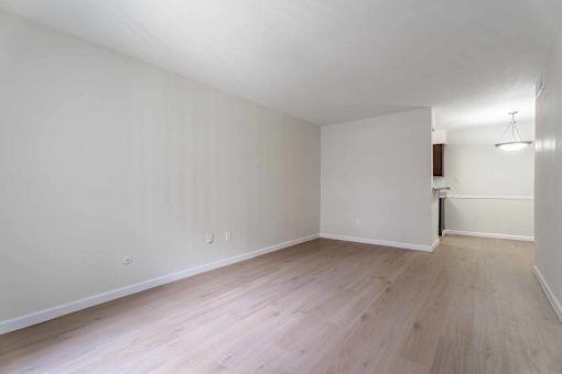 A room with wooden flooring and white walls.