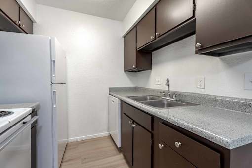 A kitchen with brown cabinets and a white refrigerator.