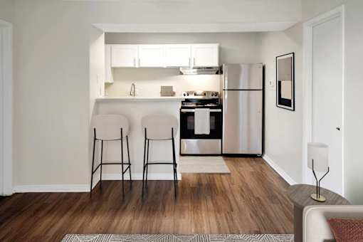 A kitchen with a refrigerator, oven, and sink is visible.