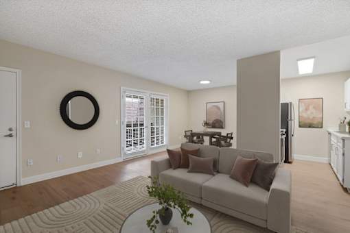 A living room with a couch, a coffee table, and a wreath on the wall.