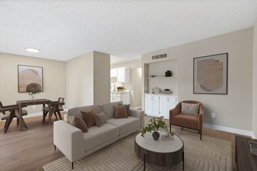 A living room with a couch, a chair, a coffee table, and a dining table.