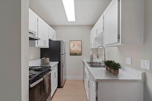 A kitchen with white cabinets and a black stove top.