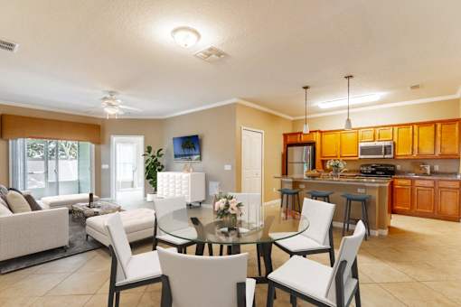 a living room and dining room with a glass table and chairs