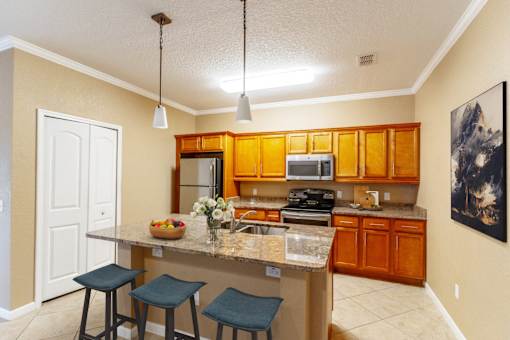 a kitchen with an island with stools and a sink