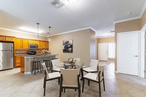 a dining room and kitchen with a table and chairs