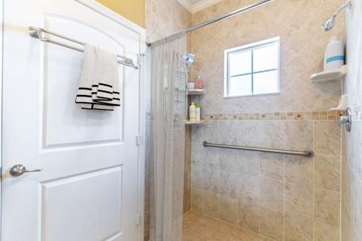 a bathroom with a shower and a white door