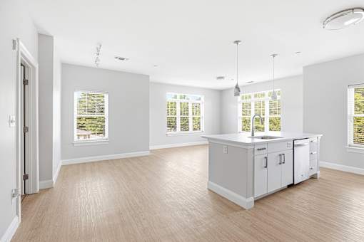 A kitchen with a white cabinet and a window with blinds.