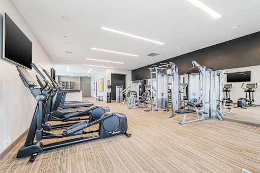 A gym with treadmills, weights, and exercise machines. at Axis at Lakeshore, Massachusetts
