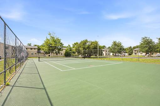 A tennis court surrounded by a fence.