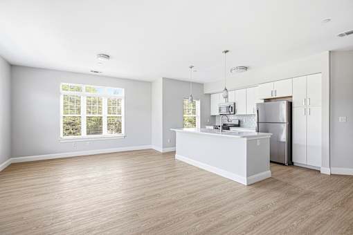 A kitchen with a white counter and wooden floors.