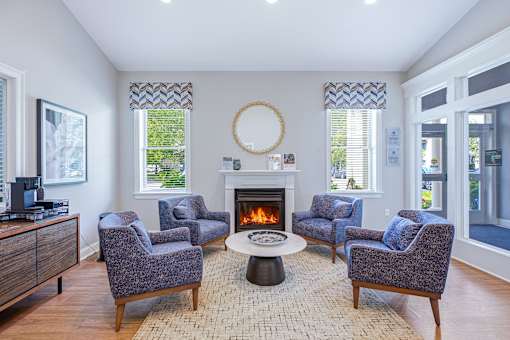 A living room with a fireplace and grey chairs.
