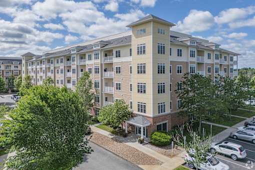 A large apartment complex with a parking lot in front.