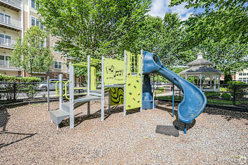 A playground with a blue slide and a yellow climbing frame.