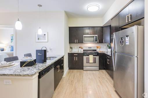 A kitchen with a refrigerator, oven, and microwave.