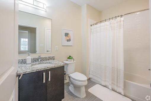 A bathroom with a toilet, sink, and shower.