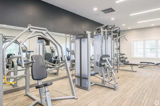 A gym with a variety of equipment including a leg press machine.