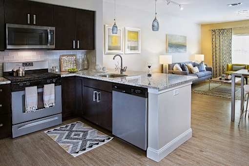 A modern kitchen with dark brown cabinets and a white island at Axis at Lakeshore Apartments, Bridgewater