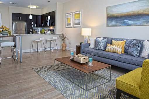 A modern living room with a Blue couch and a coffee table at Axis at Lakeshore Apartments, Massachusetts, 02324