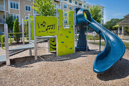 A playground with a slide and a sign that says at Axis at Lakeshore Apartments, Bridgewater, Massachusetts