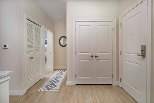A hallway with white doors and a patterned rug on the floor at Axis at Lakeshore Apartments, MA,02324