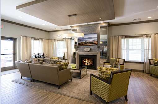 A living room with a fireplace and a couch at Axis at Lakeshore Apartments, Bridgewater, MA 02324