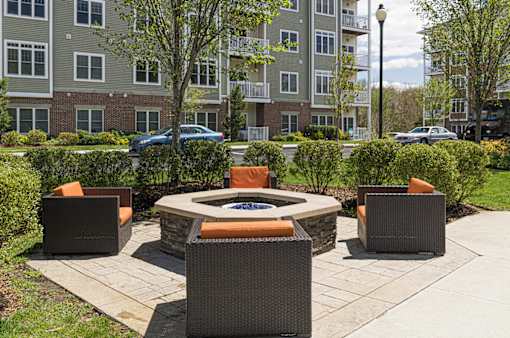 A patio with a fire pit and chairs at Axis at Lakeshore Apartments, Bridgewater
