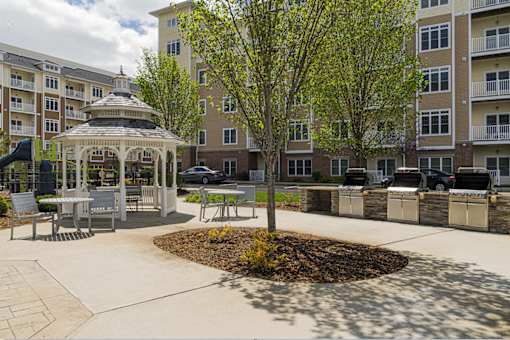 A gazebo is surrounded by a paved walkway and a tree in a courtyard at Axis at Lakeshore Apartments, Massachusetts