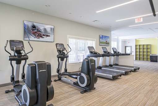 A gym with treadmills and elliptical machines at Axis at Lakeshore Apartments, Bridgewater, Massachusetts